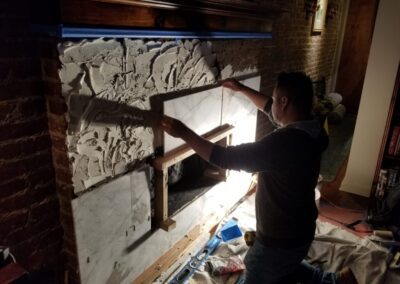 A man is working on a stone wall